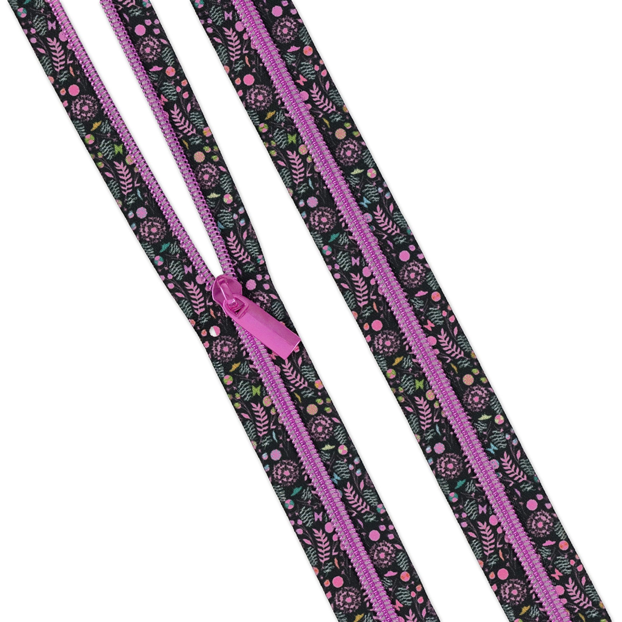 Tula Pink Dandelion #5 zipper tape showing dark background botanical print with pink dandelion flowers, green fern sprigs, and colorful dots, with hot pink metallic coils and pull, from the Prince Charming Deja Vu Collection