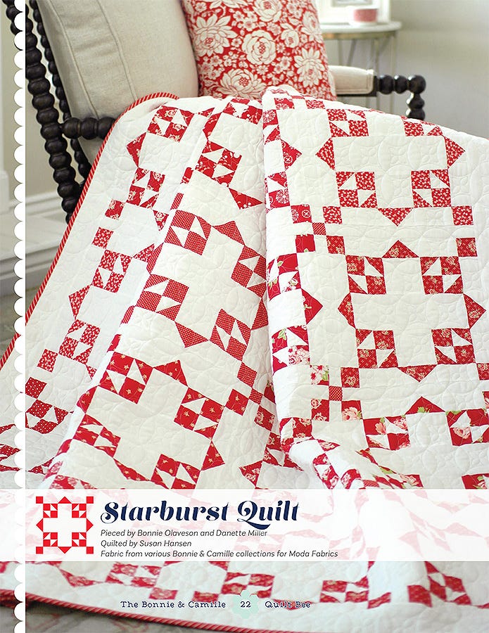 Starburst Quilt from The Bonnie & Camille Quilt Bee, red and cream star blocks on a bed.