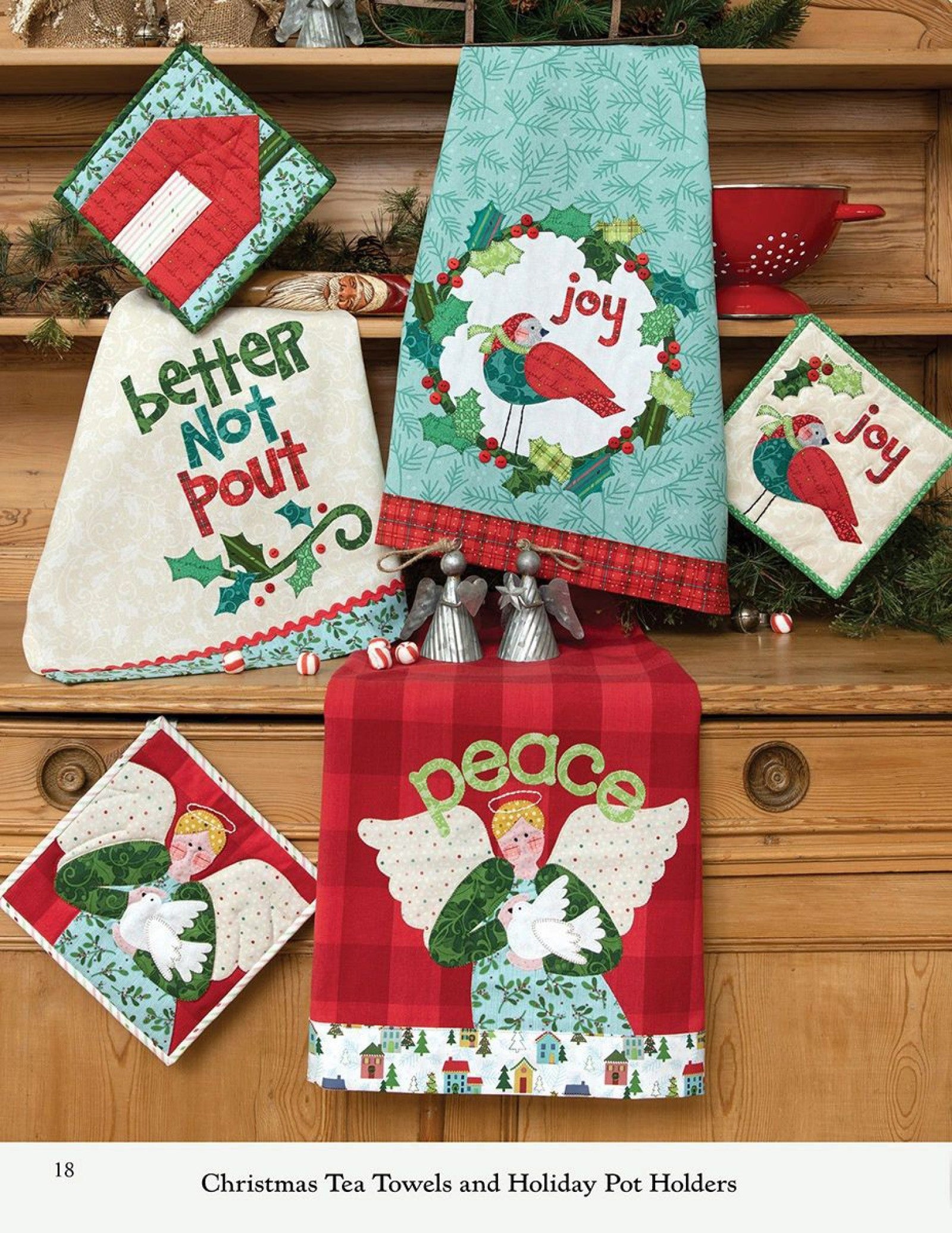 Interior page of the Better Not Pout quilt pattern book by Nancy Halvorsen of Art to Heart, showing Christmas tea towels and holiday pot holders appliqued with a wreath, a peace angel, and Better Not Pout lettering.