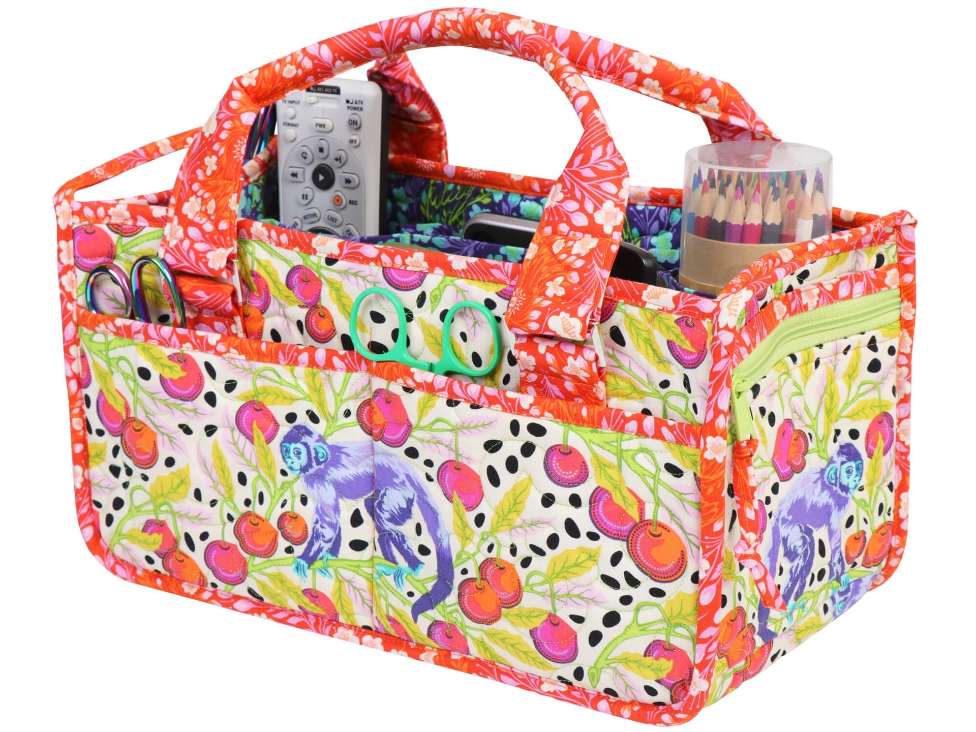 Catch All Caddy 2.0 sewn in a colorful floral and animal print with orange binding, filled with rulers, scissors, and colored pencils, showing the exterior slip pockets and an embroidered ByAnnie logo.
