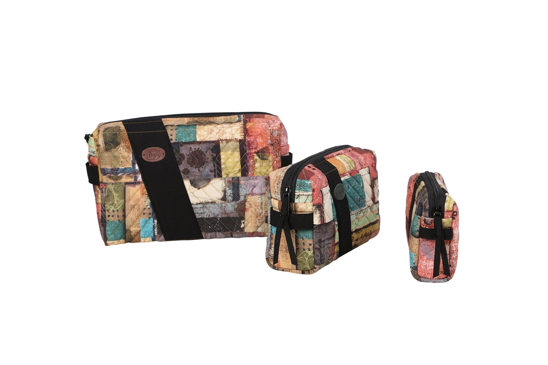 Three Ditty Bags sewn in earthy patchwork batik prints, shown small, medium, and large with side handles.