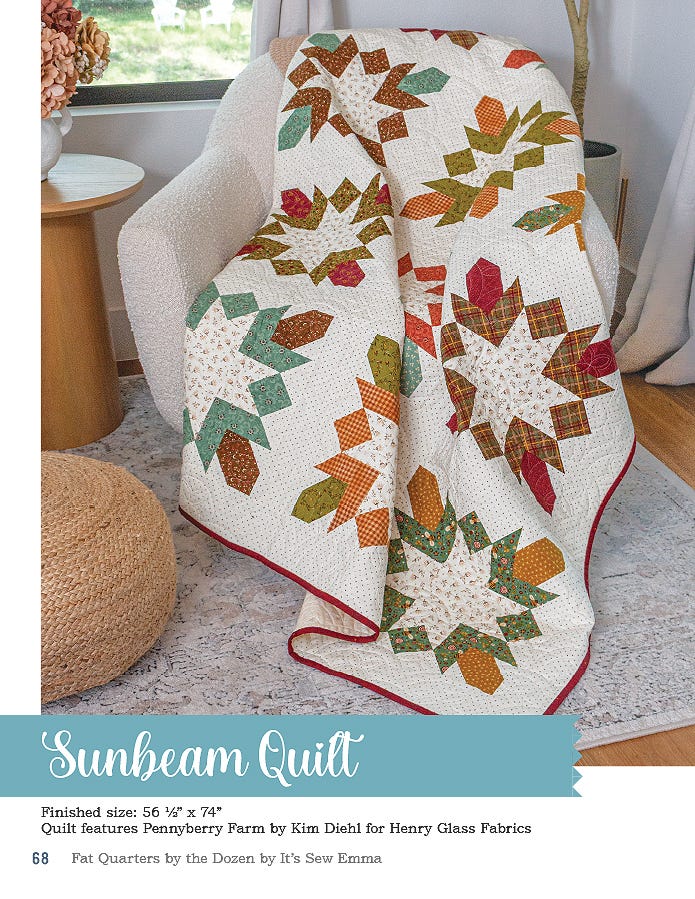 The Sunbeam quilt, 56.5 x 74 inches, pieced autumn-toned star blocks on cream, draped over a chair.