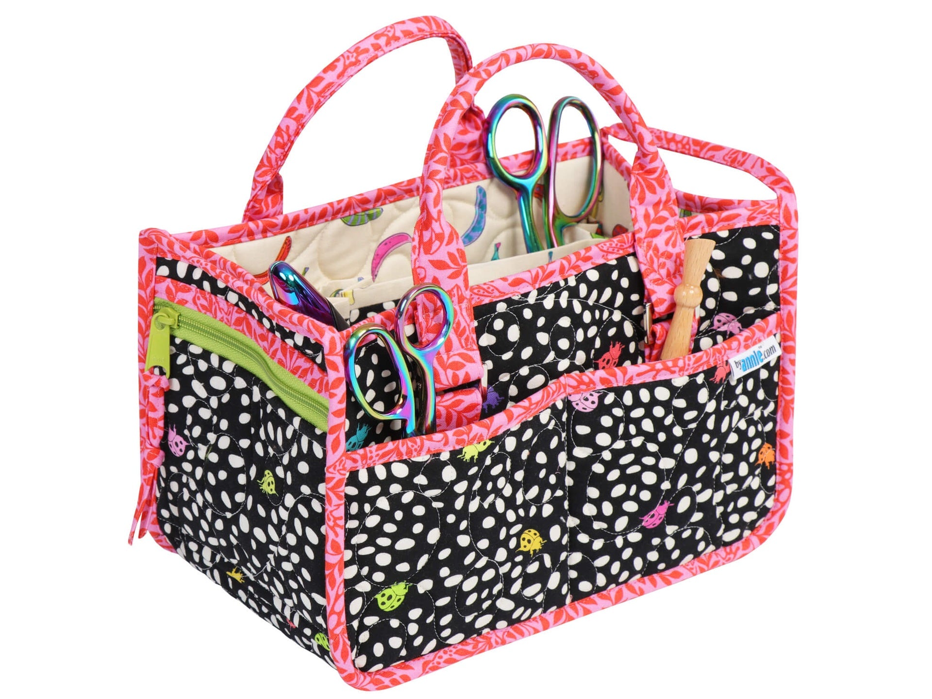 In Control Caddy sewn in a black and white dot print with pink binding, filled with sewing notions including scissors and a seam ripper in the outer pockets.