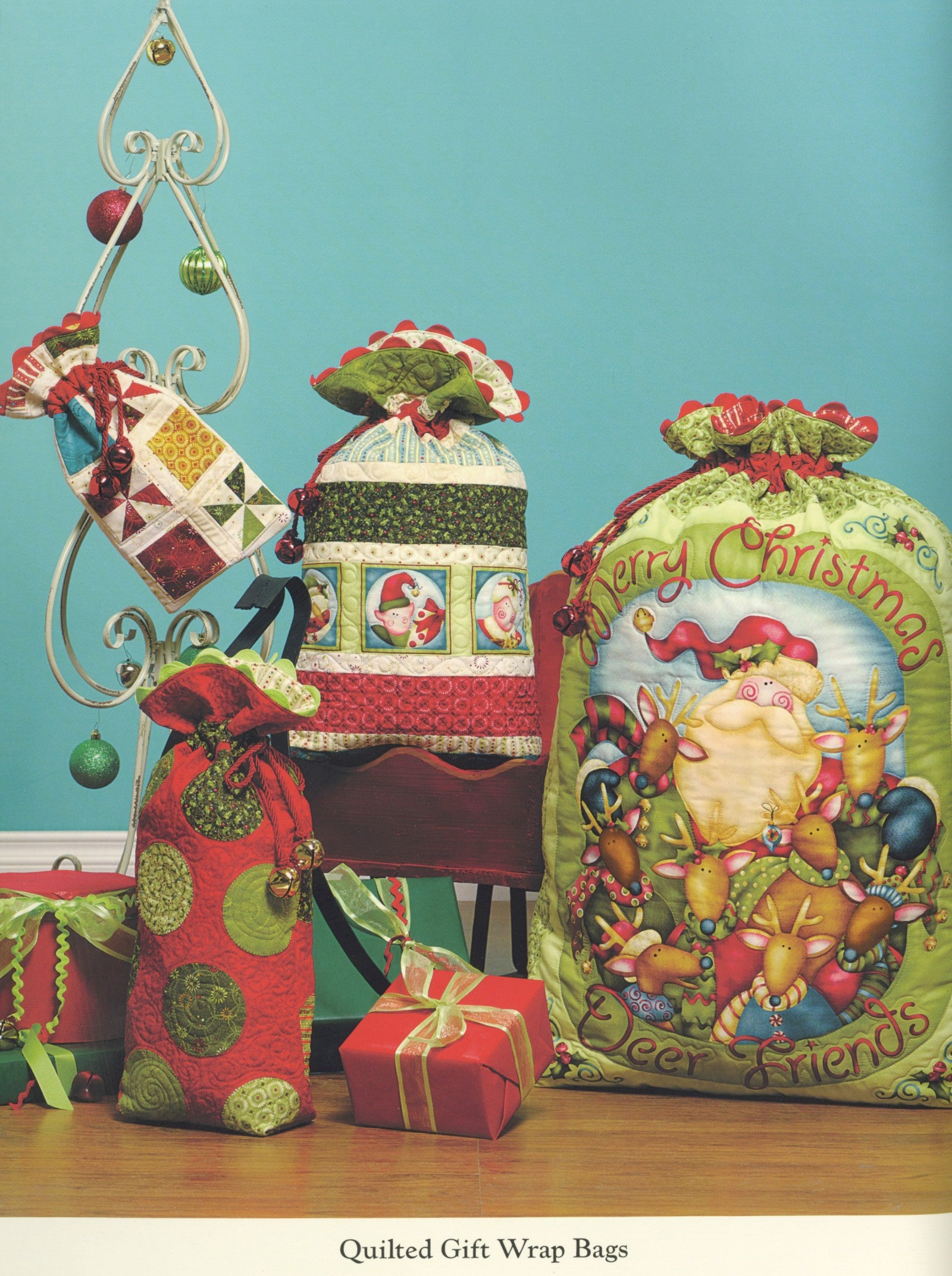 Interior page of the Jingle All The Way quilt pattern book by Nancy Halvorsen of Art to Heart, showing Quilted Gift Wrap Bags appliqued with Santa and Christmas motifs.