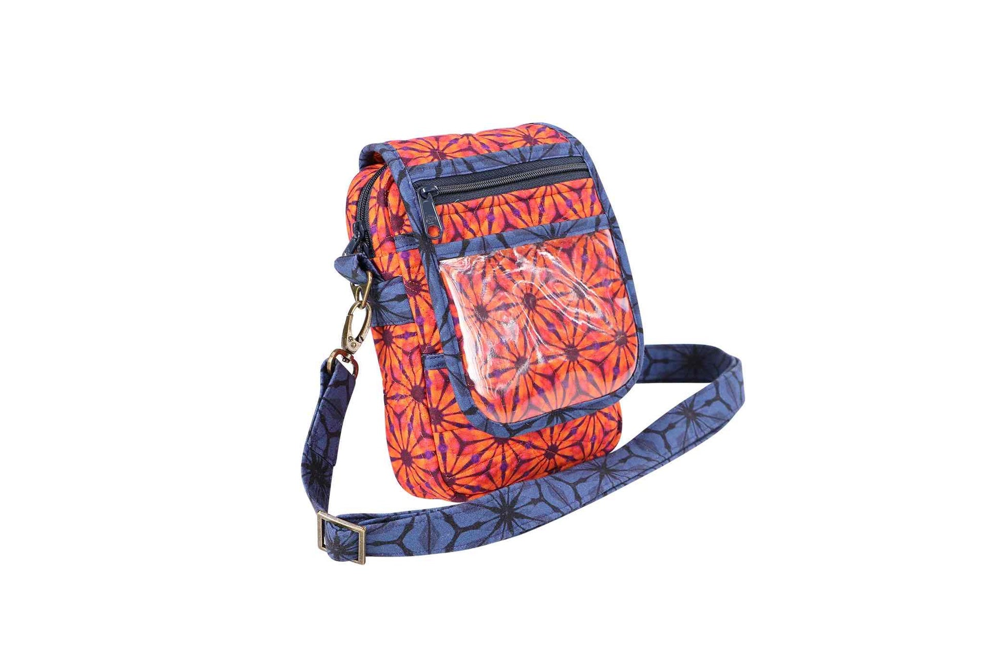 An On the Go bag in an orange and blue print shown from the front with a clear ID window pocket and crossbody strap.