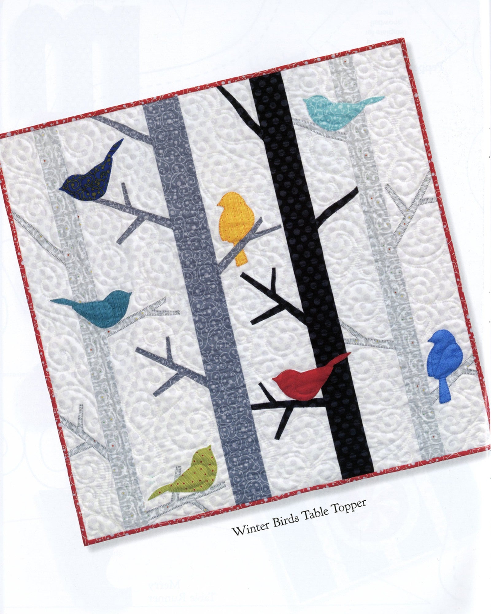 Interior page of the Table Please Part Two quilt pattern book by Nancy Halvorsen of Art to Heart, showing the Winter Birds table topper with appliqued birds among birch trees.