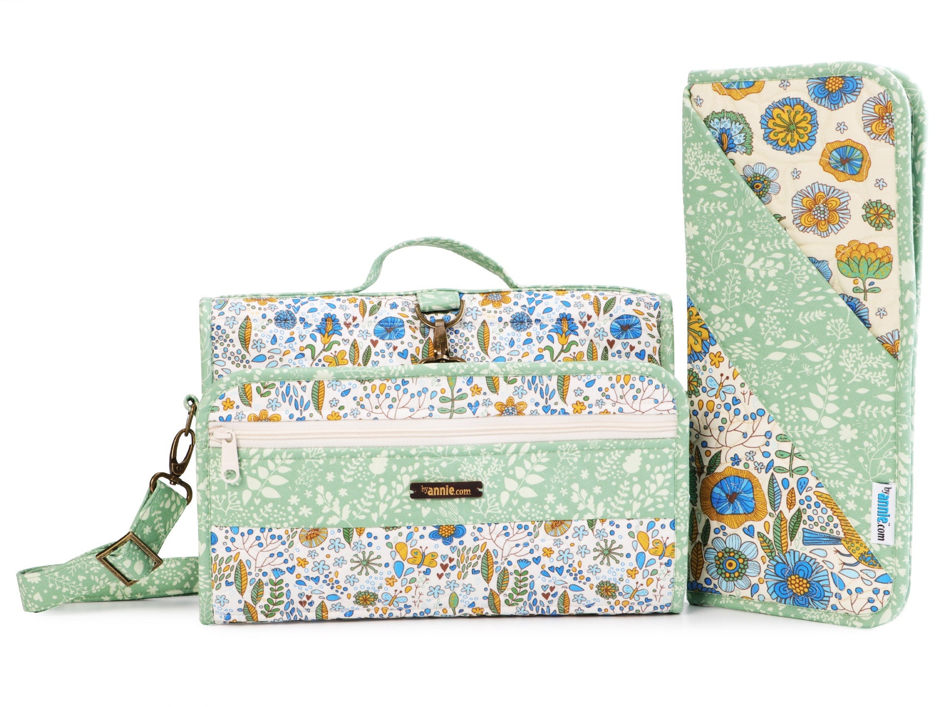 A green floral Travel Essentials organizer folded closed with a carrying strap, beside the matching hot tools sleeve.